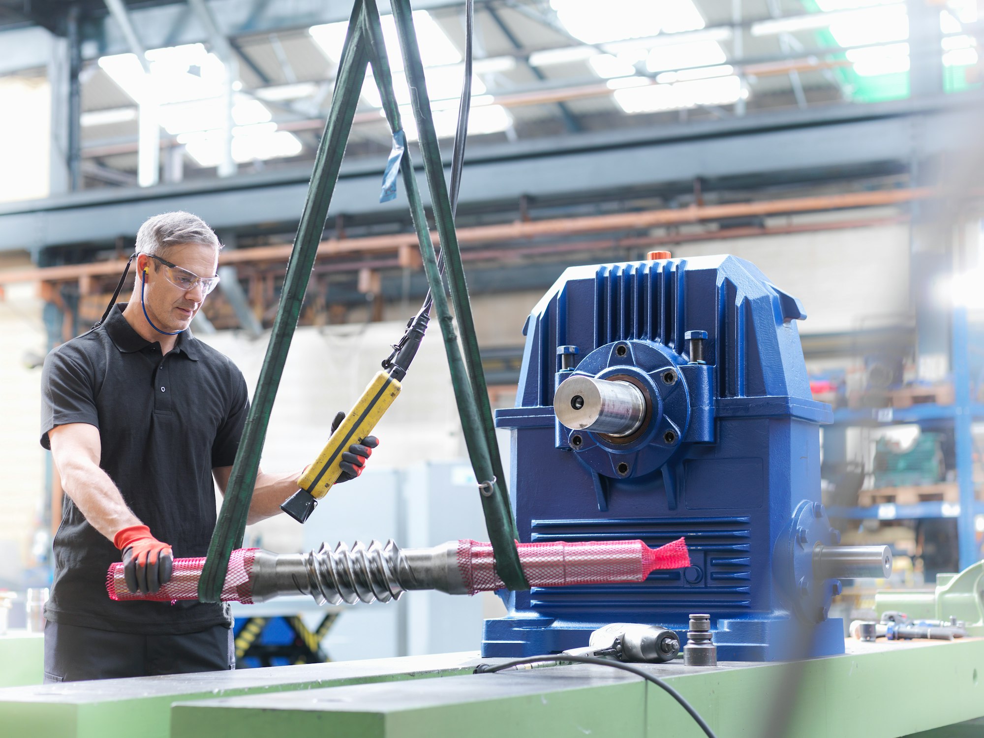 Engineer assembling industrial gearbox in engineering factory