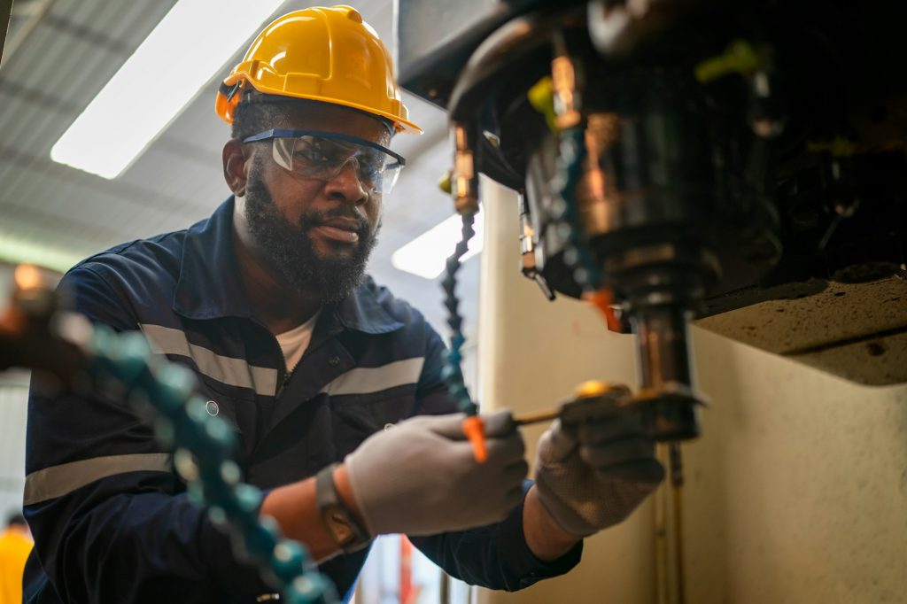 Robotics engineer fitting sensors to traditional engineering lathe in robotics research facility